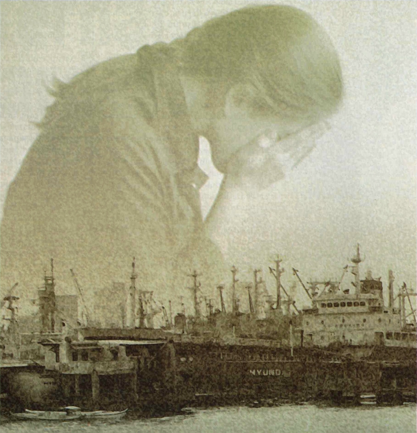 In foreground, ships docked at an old pier; in background, a woman with her face in her hands