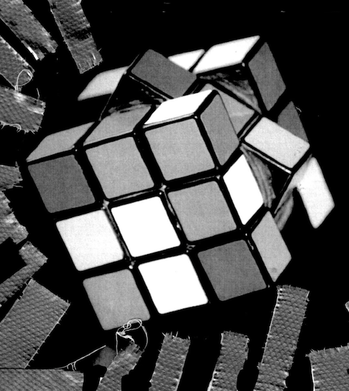 Black and white photograph of a rubik's cube with duct tape along the edges.